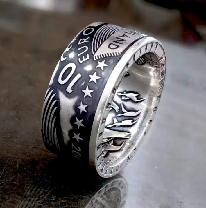 Handcrafted silver coin ring on a wooden surface